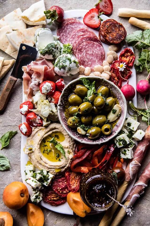 Looking for some amazing charcuterie board ideas to wow your guests on your next holiday parties? Learn how to make a charcuterie board plus get a list of the best cheese boards perfect for a crowd! #appetizers | simple charcuterie board | easy charcuterie board | cheap charcuterie board | food platter | entertaining | fall charcuterie board | thanksgiving charcuterie board | Image via Half Baked Harvest