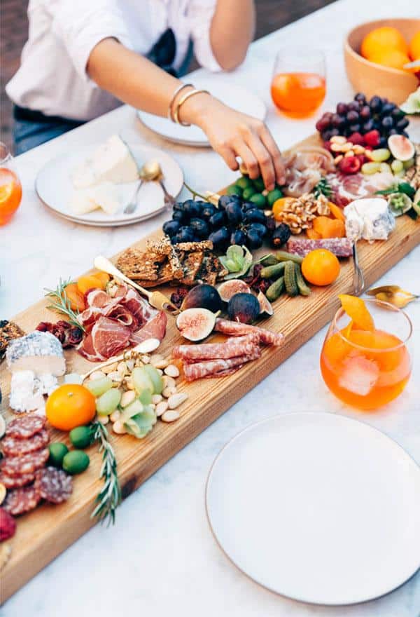 Looking for some amazing charcuterie board ideas to wow your guests on your next holiday parties? Learn how to make a charcuterie board plus get a list of the best cheese boards perfect for a crowd! #appetizers | simple charcuterie board | easy charcuterie board | cheap charcuterie board | food platter | entertaining | fall charcuterie board | thanksgiving charcuterie board | Image via APT.34