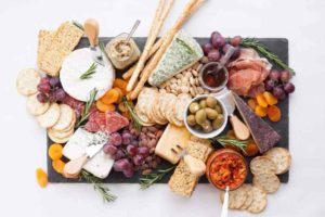 Looking for some amazing charcuterie board ideas to wow your guests on your next holiday parties? Learn how to make a charcuterie board plus get a list of the best cheese boards perfect for a crowd! #appetizers | simple charcuterie board | easy charcuterie board | cheap charcuterie board | food platter | entertaining | fall charcuterie board | thanksgiving charcuterie board | Image via Wholefully