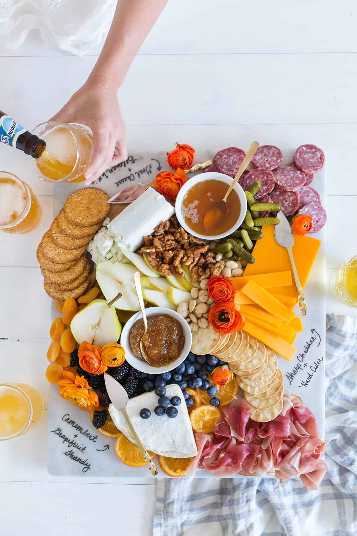 Looking for some amazing charcuterie board ideas to wow your guests on your next holiday parties? Learn how to make a charcuterie board plus get a list of the best cheese boards perfect for a crowd! #appetizers | simple charcuterie board | easy charcuterie board | cheap charcuterie board | food platter | entertaining | fall charcuterie board | thanksgiving charcuterie board | Image via Freut Cake