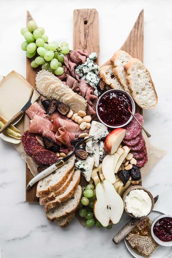 Looking for some amazing charcuterie board ideas to wow your guests on your next holiday parties? Learn how to make a charcuterie board plus get a list of the best cheese boards perfect for a crowd! #appetizers | simple charcuterie board | easy charcuterie board | cheap charcuterie board | food platter | entertaining | fall charcuterie board | thanksgiving charcuterie board | Image via The Modern Proper