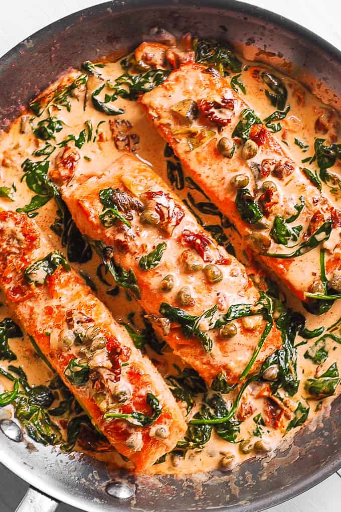 CREAMY TUSCAN SALMON WITH SPINACH, ARTICHOKES, AND GARLIC via Julias Album. Healthy, easy, and incredibly delicious salmon recipes you'll want to eat over and over again for breakfast,  lunch, or dinner! Find baked salmon, grilled salmon, smoked, pan-seared, and more!
