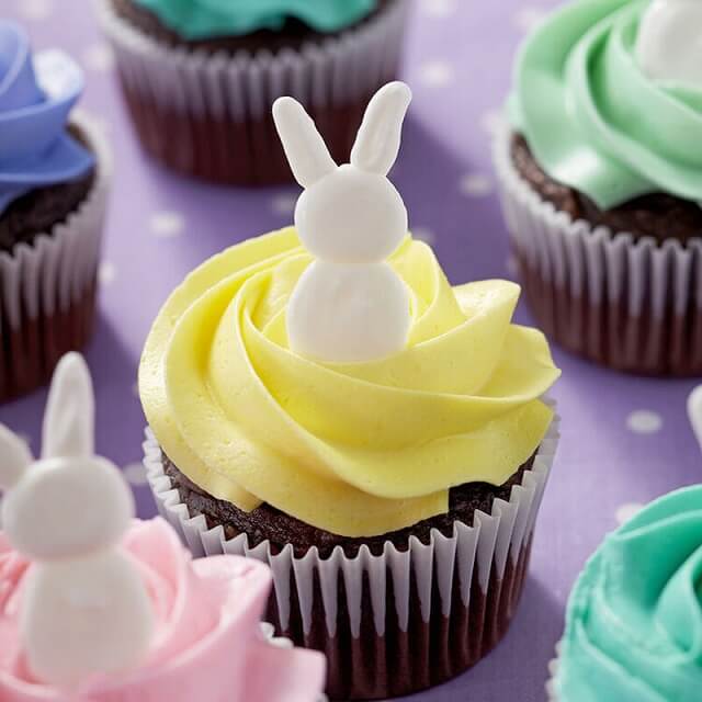 The adorable bunnies that sit on the colorful frosting on top of the cupcakes are adorably abstract, with bunny ears, heads, and bodies made of melted Candy Melts Candy.