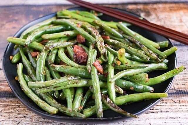 Traditional Szechuan cuisine is Chinese dry-fried green beans, which are scorched in a hot wok with flavorful ground pork, garlic, ginger, and chilies.