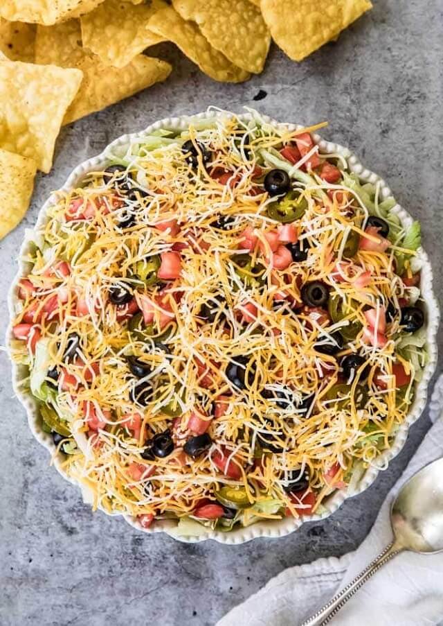 It's prepared with traditional cream cheese and sour cream base, taco seasoning (you can use a pre-made packet or make your own), and all of your favorite taco toppings.