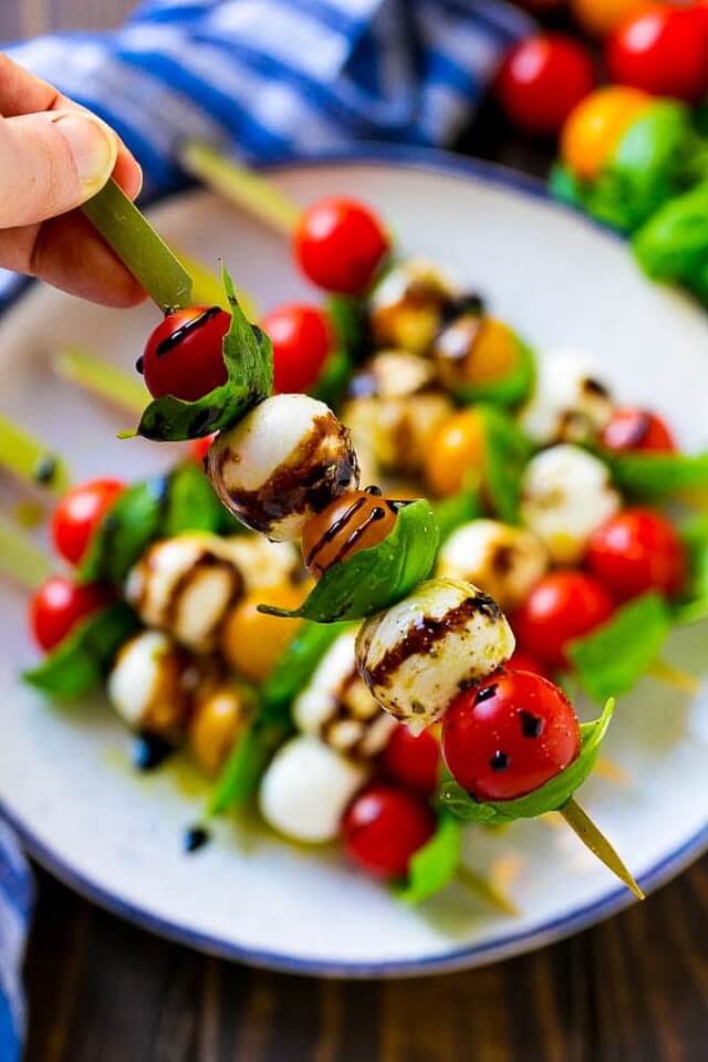 These Caprese skewers are a quick and elegant appetizer that blends tomatoes, basil, mozzarella, olive oil, and balsamic vinegar.