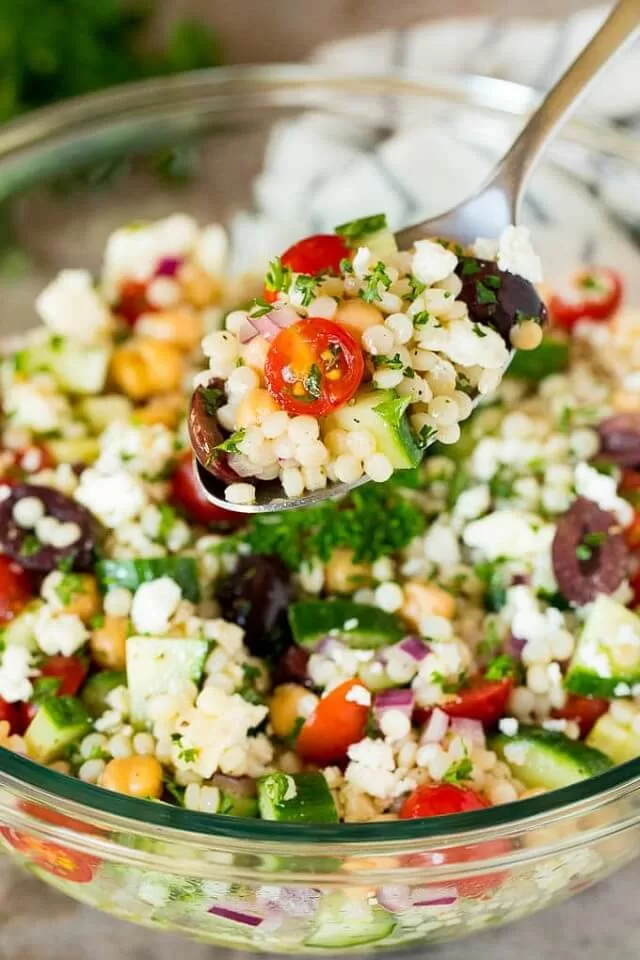 Pearl couscous, vegetables, and feta cheese are combined in a homemade dressing for this Mediterranean couscous salad.