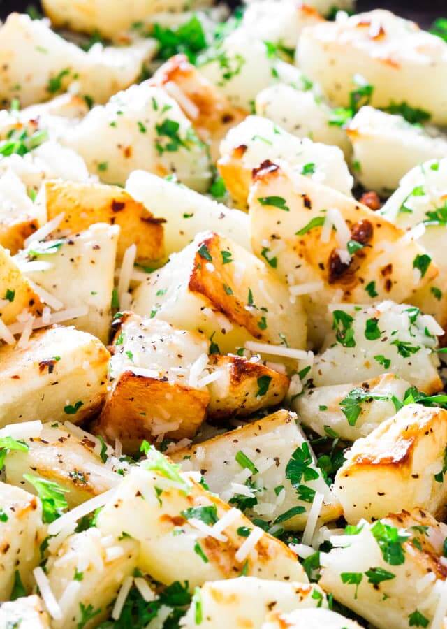 Tender potatoes roasted to golden perfection and tossed with garlic, parmesan cheese, and fresh herbs are a savory side dish that pairs perfectly with any grilled meat.