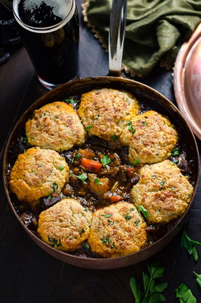 Fluffy dumplings sit on top of a thick, savory stew, soaking up all the rich flavors.