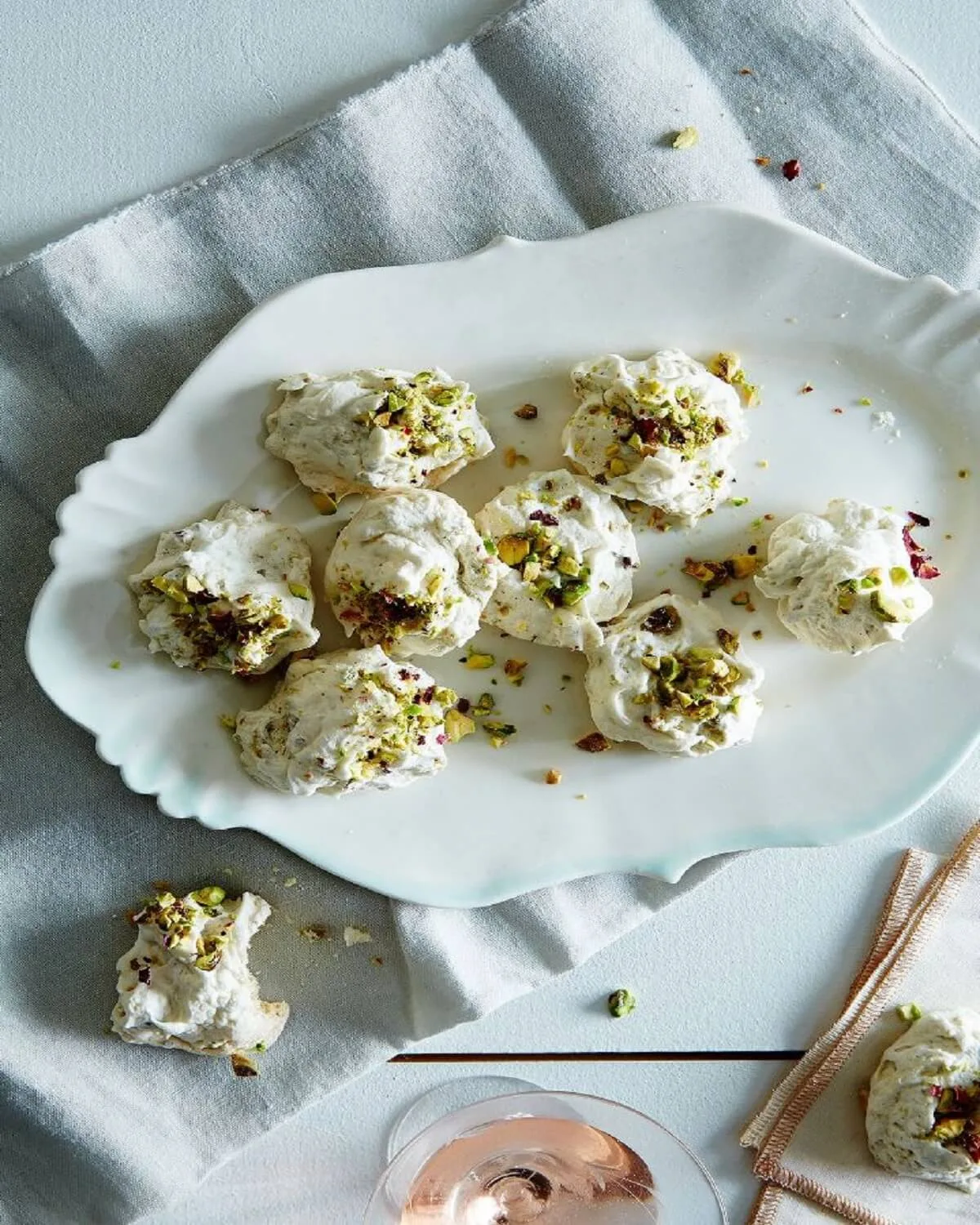 A deconstructed dessert plate featuring shelled pistachios, honeycomb, and a drizzle of clover honey.