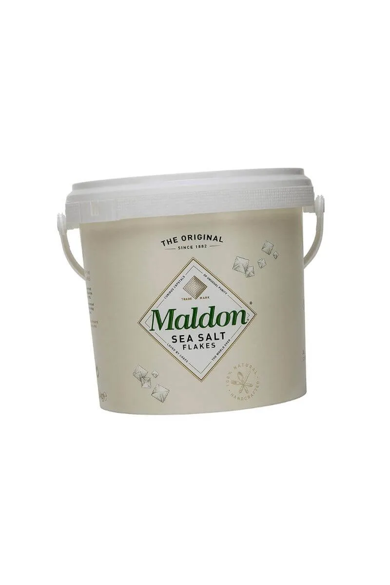 Maldon sea salt flakes in a small ceramic bowl for architectural seasoning and texture.