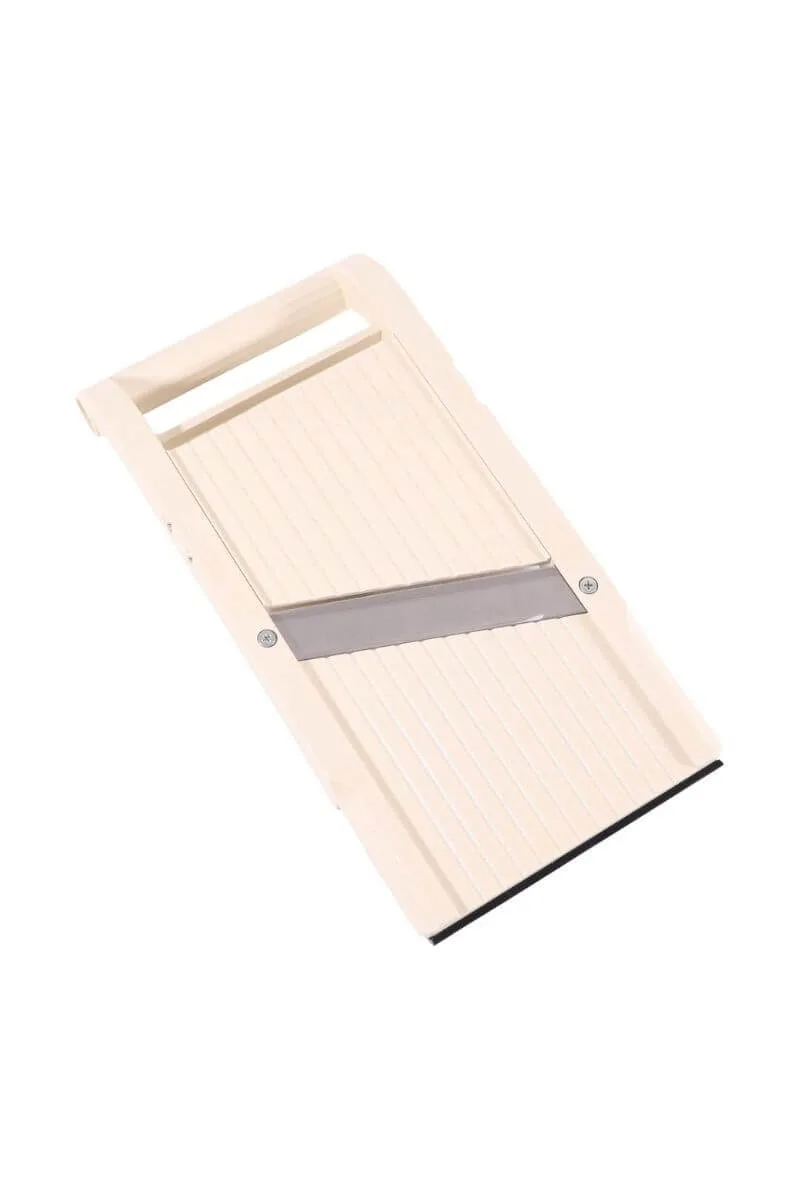 Minimalist Benriner Japanese mandoline slicer on a white kitchen counter for professional vegetable assembly.
