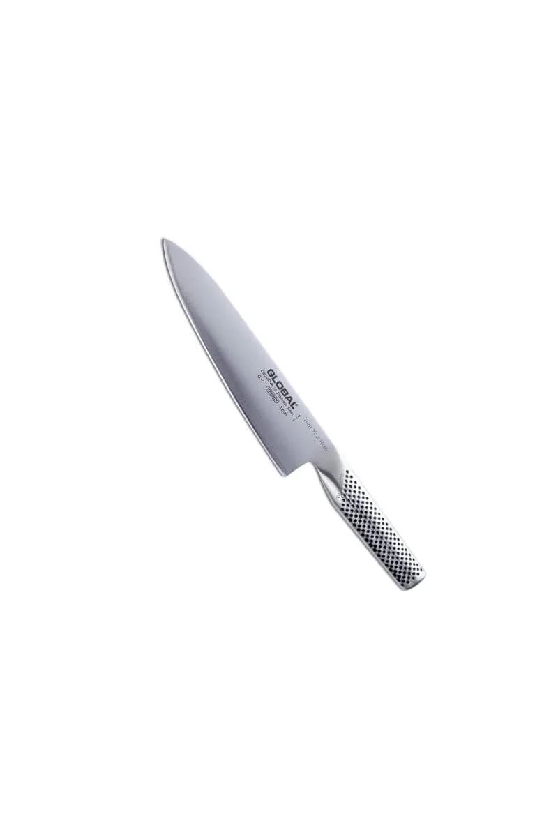 Global G-2 Japanese stainless steel chef's knife resting on a wooden cutting board in a sunlit kitchen.